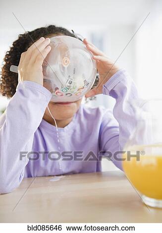 Stock Photograph - African American girl eating cereal. Fotosearch