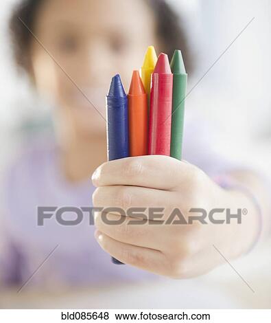 Stock Photo - African American girl holding crayons. Fotosearch