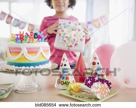 African American girl holding gift at birthday party View Large Photo Image Picture - African American girl holding gift at birthday party. Fotosearch