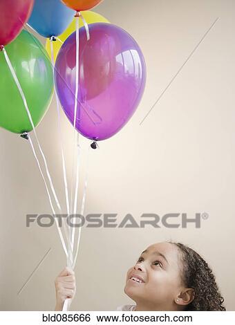 African American girl holding helium balloons View Large Photo Image Stock Photograph - African American girl holding helium balloons. Fotosearch