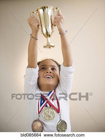 African American girl holding up trophy View Large Photo Image Picture - African American girl holding up trophy. Fotosearch