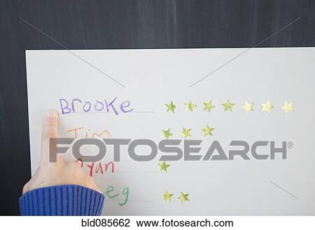 Stock Image - African American girl pointing at a name and stars. Fotosearch