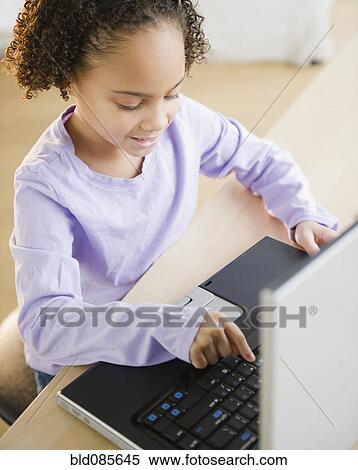 Stock Photography - African American girl using laptop. Fotosearch