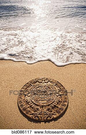 Aztec calendar stone carving on sandy beach View Large Photo Image Stock Photo - Aztec calendar stone carving on sandy beach. Fotosearch