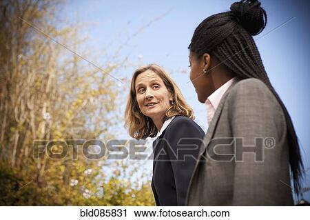 Businesswomen walking together outdoors View Large Photo Image Stock Image - Businesswomen walking together outdoors. Fotosearch