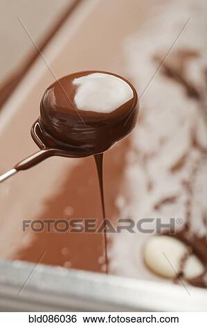 Stock Photograph - Candy dripping chocolate. Fotosearch