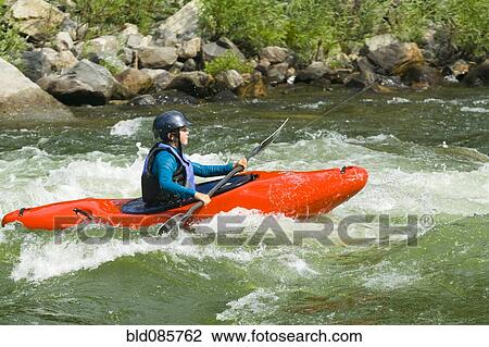 Stock Image - Caucasian girl kayaking in river. Fotosearch