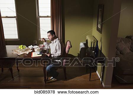 Caucasian man having dinner and reading View Large Photo Image Stock Photo - Caucasian man having dinner and reading. Fotosearch