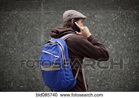 Caucasian man in backpack talking on cell phone View Large Photo Image Stock Image - Caucasian man in backpack talking on cell phone. Fotosearch