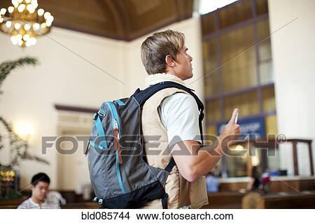 Picture - Caucasian man with backpack in train station. Fotosearch