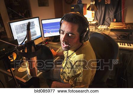 Stock Photo - Caucasian man working in music studio. Fotosearch