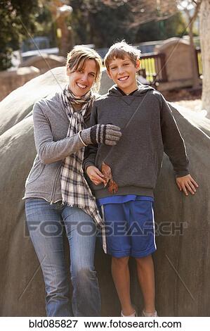 Stock Photo - Caucasian mother and son leaning against rock. Fotosearch