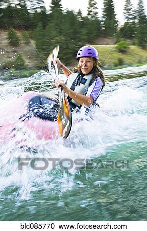 Stock Image - Caucasian teenager kayaking in river. Fotosearch
