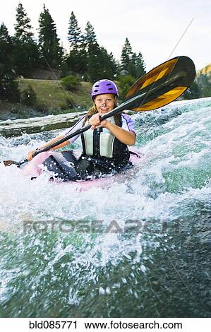 Stock Image - Caucasian teenager kayaking in river. Fotosearch