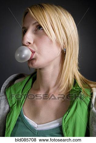 Stock Photo - Caucasian woman blowing bubble with bubble gum. Fotosearch