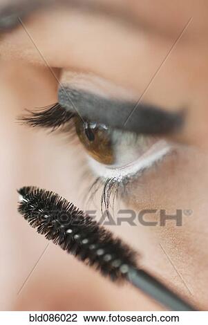 Stock Image - Caucasian woman putting on mascara. Fotosearch