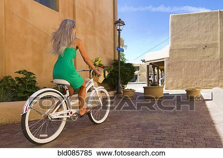 Stock Photography - Caucasian woman riding bicycle. Fotosearch