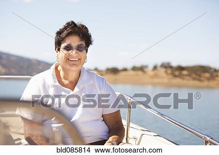 Picture - Caucasian woman sitting on boat. Fotosearch