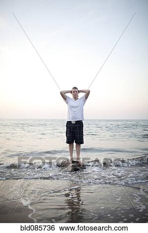 Caucasian woman standing on rock in ocean View Large Photo Image Stock Photograph - Caucasian woman standing on rock in ocean. Fotosearch
