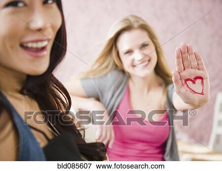 Stock Photo - Caucasian woman with heart drawn on her hand. Fotosearch