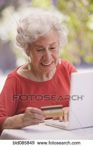 Stock Photo - Chilean woman shopping online with credit card. Fotosearch