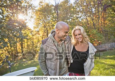 Stock Image - Couple walking in park in autumn. Fotosearch