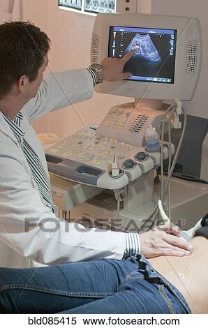 Stock Photography - Doctor giving woman a sonogram examination. Fotosearch