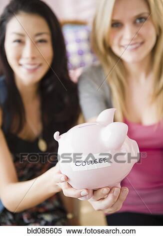 Friends holding piggy bank labeled with "college" View Large Photo Image Stock Photography - Friends holding piggy bank labeled with "college". Fotosearch
