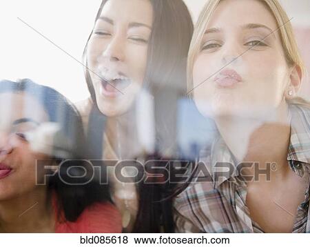 Stock Photo - Friends kissing glass. Fotosearch