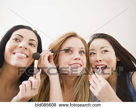 Friends putting makeup on together View Large Photo Image Stock Photo - Friends putting makeup on together. Fotosearch