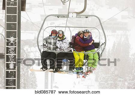 Stock Photo - Friends riding ski lift. Fotosearch