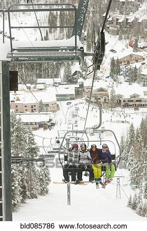 Stock Photograph - Friends riding ski lift. Fotosearch