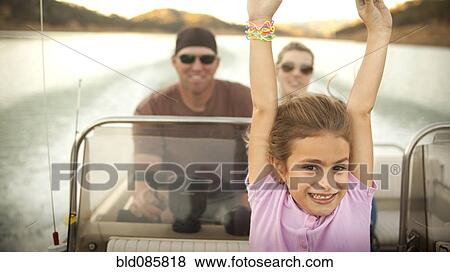 Stock Photo - Girl and parents enjoying riding on boat. Fotosearch