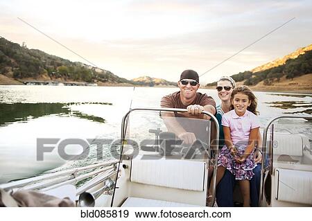 Stock Photo - Girl and parents enjoying riding on boat. Fotosearch