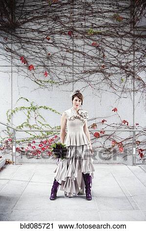 Stock Image - Glamorous bride standing with bouquet. Fotosearch