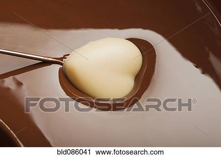Heart-shaped candy being dipped in chocolate View Large Photo Image Stock Image - Heart-shaped candy being dipped in chocolate. Fotosearch