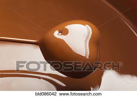 Heart-shaped candy being dipped in chocolate View Large Photo Image Stock Image - Heart-shaped candy being dipped in chocolate. Fotosearch