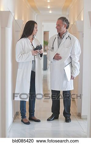 Stock Image - Hispanic doctors standing together in hospital corridor. Fotosearch
