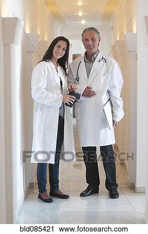 Stock Image - Hispanic doctors standing together in hospital corridor. Fotosearch