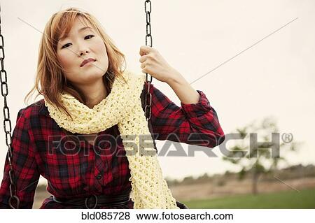 Stock Photo - Korean woman sitting on a swing. Fotosearch