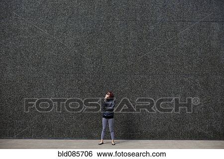 Stock Photograph - Korean woman standing in city sidewalk. Fotosearch