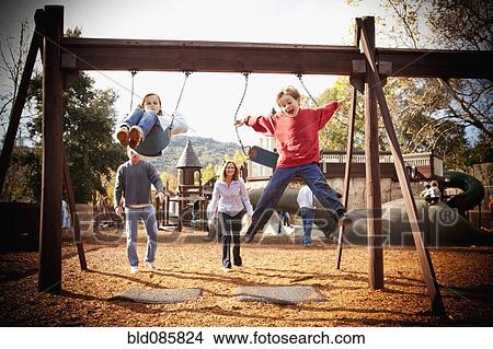 Parents watching children swinging View Large Photo Image Picture - Parents watching children swinging. Fotosearch
