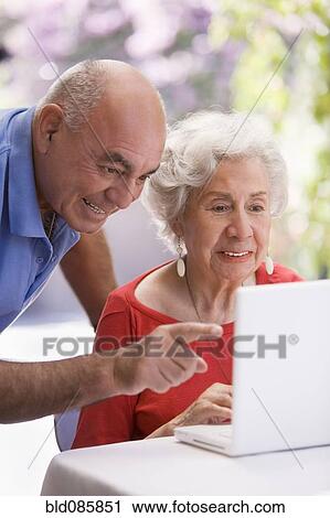 Stock Image - Senior Chilean couple using laptop. Fotosearch