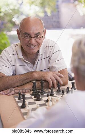 Stock Photography - Senior men playing chess outdoors. Fotosearch