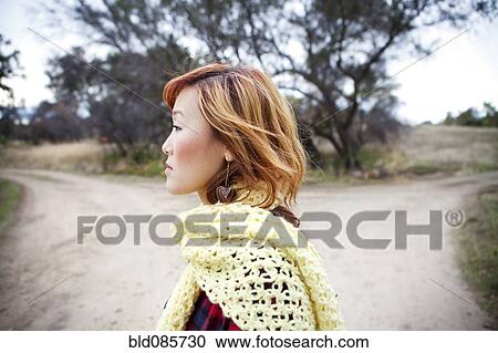 Serious Korean woman standing at fork in road View Large Photo Image Stock Image - Serious Korean woman standing at fork in road. Fotosearch