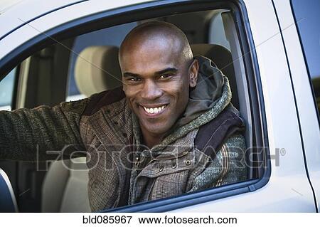 Stock Photo - Smiling African American man driving car. Fotosearch