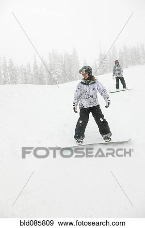 Snowboarders descending ski slope View Large Photo Image Stock Photo - Snowboarders descending ski slope. Fotosearch