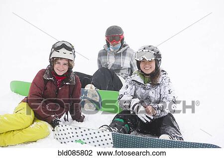 Snowboarders sitting in the snow View Large Photo Image Stock Image - Snowboarders sitting in the snow. Fotosearch