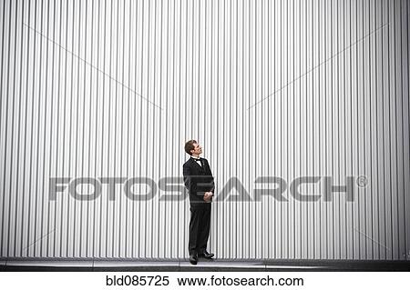 Stock Photography - Uncertain groom standing near wall. Fotosearch