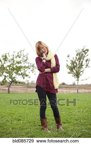 Stock Photo - Unhappy Korean woman standing in park. Fotosearch